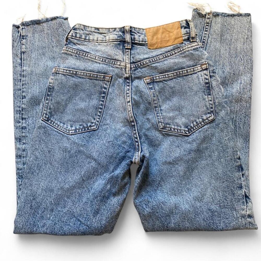 High waisted blue denim jeans with distressed ends